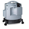 A compact, gray industrial floor cleaning machine on wheels.